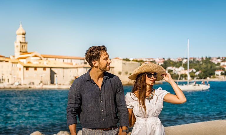 Ein Mann und eine Frau stehen nebeneinander und schauen aufs Meer