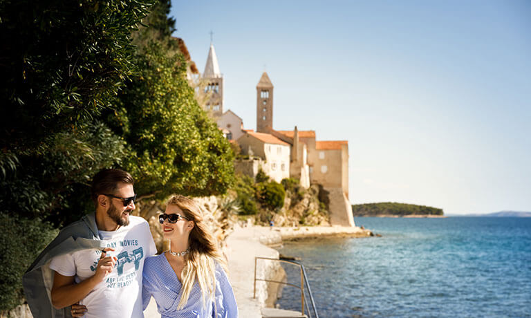 a man and woman posing for a picture next to a body of water